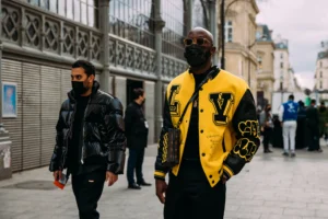 two mens walking wearing yellow and black jackets on the streat