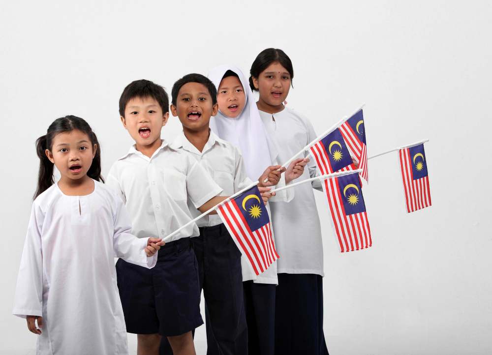 Malaysian school children holding Malaysian flag.