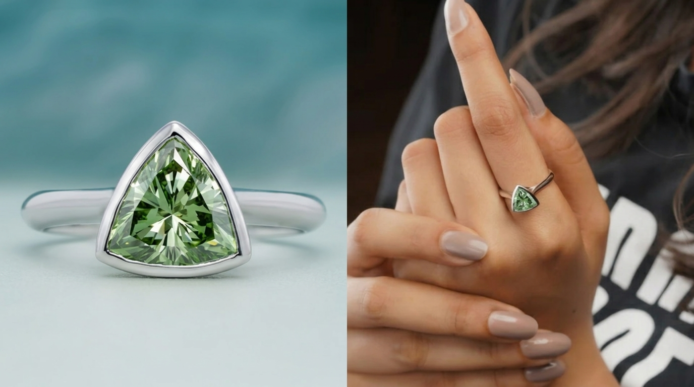 Close-up of a trillion cut green diamond ring set in white gold, shown in a bezel setting and worn on a finger.